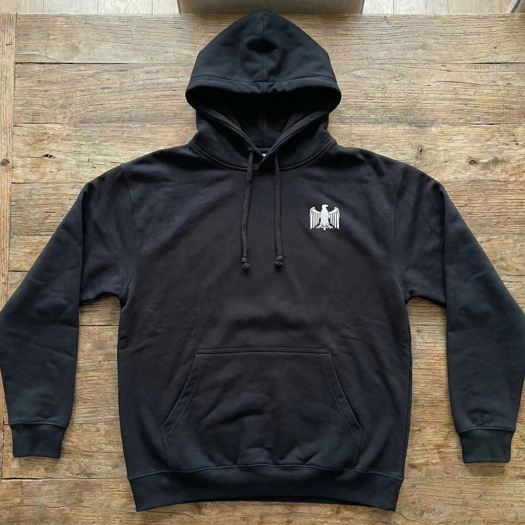 Schwarzer Adler Hoodie flach liegend auf Holz